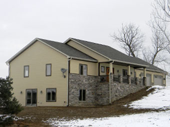 A tan home with snowy yard
